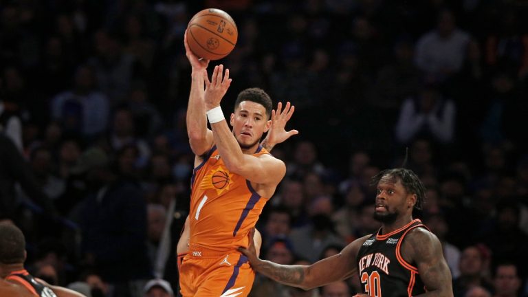 Phoenix Suns' Devin Booker (1) looks to pass over New York Knicks' Julius Randle (30) during the first half of an NBA basketball game Friday, Nov. 26, 2021, in New York. (John Munson/AP) 