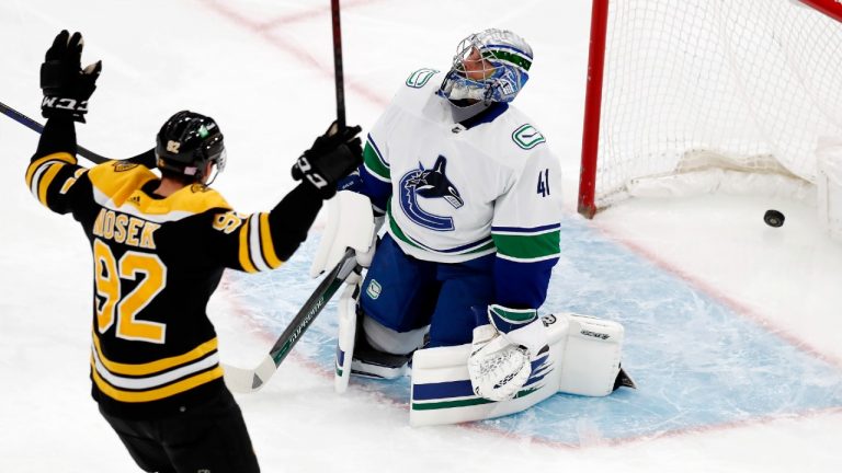 Boston Bruins' Tomas Nosek (92) celebrates the goal by Anton Blidh on Vancouver Canucks' Jaroslav Halak (41) during the first period of an NHL hockey game, Sunday, Nov. 28, 2021, in Boston. (AP Photo/Michael Dwyer) 
