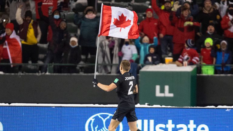 Canada's Alistair Johnston (2) parades the flag to celebrate the win over Mexico during World Cup Qualifiers in Edmonton. (Jason Franson/CP)