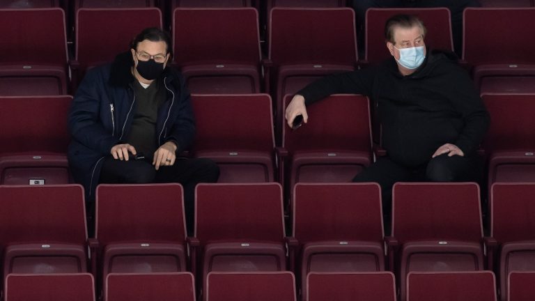 Vancouver Canucks owner Francesco Aquilini, left, and general manager Jim Benning watch the NHL hockey team's training camp in Vancouver, on Monday, January 11, 2021. (Darryl Dyck/THE CANADIAN PRESS)
