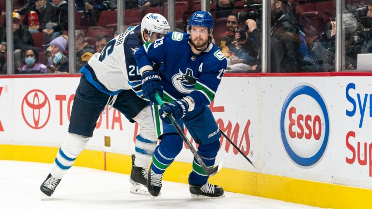 Vancouver Canucks' Oliver Ekman-Larsson (right) tries to break free from Winnipeg Jets' Blake Wheeler during first period NHL hockey action in Vancouver, B.C., Friday, Nov. 19, 2021. (Rich Lam/THE CANADIAN PRESS)
