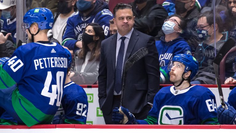 Vancouver Canucks head coach Travis Green, centre, stands on the bench behind Elias Pettersson, of Sweden, and Tyler Motte during third period NHL hockey action against the Chicago Blackhawks, in Vancouver, B.C., Sunday, Nov. 21, 2021. (Darryl Dyck/CP) 