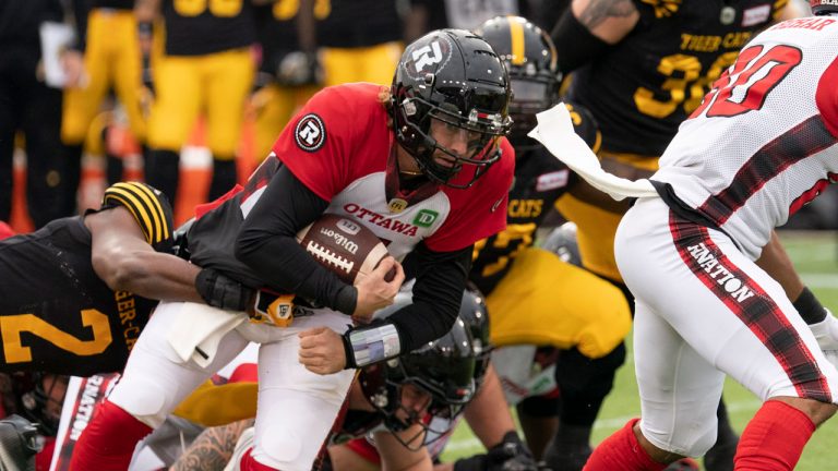 Ottawa Redblacks quarterback Devlin Hodges (7) holds on for some short yards during first half CFL football game action against the Hamilton Tiger Cats. (Peter Power/CP)