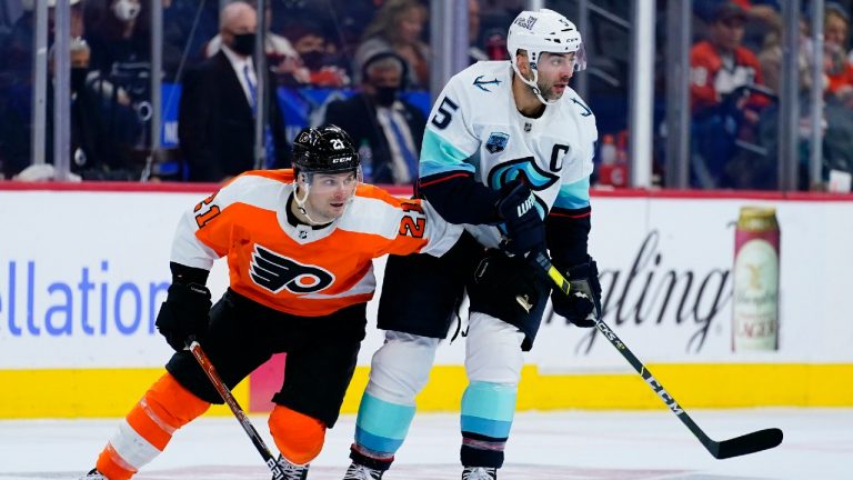 Philadelphia Flyers' Scott Laughton, left, and Seattle Kraken's Mark Giordano chase down a loose puck during the second period of an NHL hockey game, Monday, Oct. 18, 2021, in Philadelphia. (Matt Slocum/AP) 