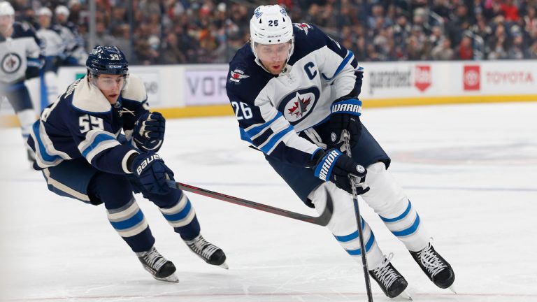 Winnipeg Jets' Blake Wheeler, right, carries the puck up ice as Columbus Blue Jackets' Yegor Chinakhov defends during the first period of an NHL hockey game. (AP) 