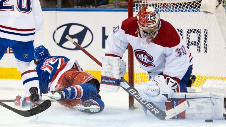 Montreal Canadiens goaltender Cayden Primeau (30) blocks the puck after defenseman Chris Wideman (20) tripped up New York Rangers center Kevin Rooney (17) during the third period of an NHL Hockey game, Tuesday, Nov. 16, 2021, in New York. (Jessie Alcheh/AP Photo) 
