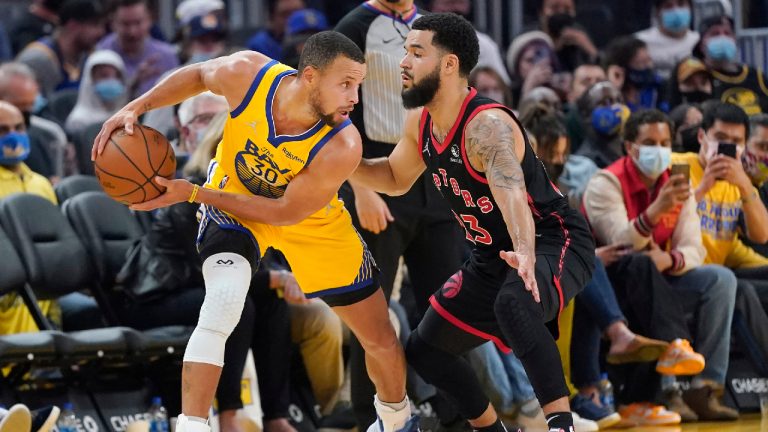 Golden State Warriors guard Stephen Curry, left, is defended by Toronto Raptors guard Fred VanVleet during the first half of an NBA basketball game in San Francisco, Sunday, Nov. 21, 2021. (Jeff Chiu/AP) 