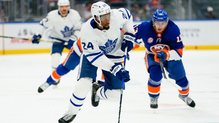 Toronto Maple Leafs' Wayne Simmonds (24) drives past New York Islanders' Mathew Barzal (13) during the third period of an NHL hockey game Sunday, Nov. 21, 2021, in Elmont, N.Y. The Maple Leafs won 3-0. (Frank Franklin II/AP Photo) 
