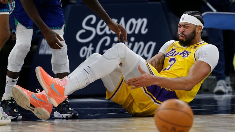 Los Angeles Lakers forward Anthony Davis (3) holds his leg after falling in the third quarter of an NBA basketball game with the Minnesota Timberwolves Friday, Dec. 17, 2021, in Minneapolis. The Timberwolves won 110-92 (Bruce Kluckhohn/AP).