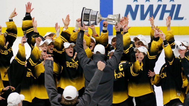 Boston Pride players cheer as coach Paul Mara hoists the NWHL Isobel Cup trophy after the team's win over the Minnesota Whitecaps in the 2021 championship game. (Mary Schwalm/AP)