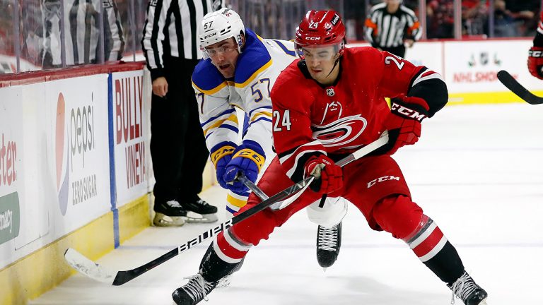 Carolina Hurricanes' Seth Jarvis (24) tries to regain control of the puck in front of Buffalo Sabres' Brett Murray (57) during the third period of an NHL hockey game in Raleigh, N.C., Saturday, Dec. 4, 2021. (Karl B DeBlaker/AP)