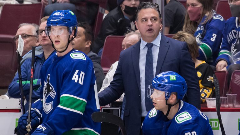 Former Vancouver Canucks head coach Travis Green stands on the bench behind Elias Pettersson (40) and Alex Chiasson (39) during the third period of an NHL hockey game against the Pittsburgh Penguins in Vancouver, on Saturday, December 4, 2021. (Darryl Dyck/CP)