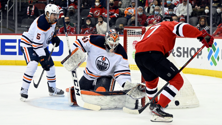 Edmonton Oilers goaltender Mike Smith deflects the puck as New Jersey Devils center Pavel Zacha (37) looks for a rebound during the first period on Friday, Dec. 31, 2021, in Newark, N.J. (AP)