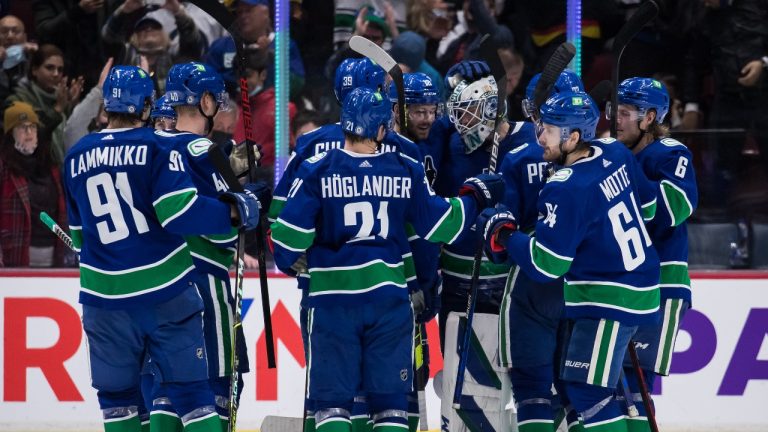 Vancouver Canucks goalie Thatcher Demko, back right, celebrates with his teammates after Vancouver defeated the Winnipeg Jets during a shootout during an NHL hockey game in Vancouver, on Friday, December 10, 2021. (Darryl Dyck/THE CANADIAN PRESS) 
