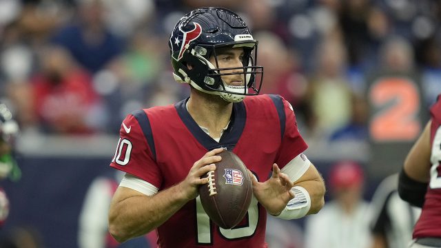 Davis Mills of the Houston Texans throws a pass against Chad Muma