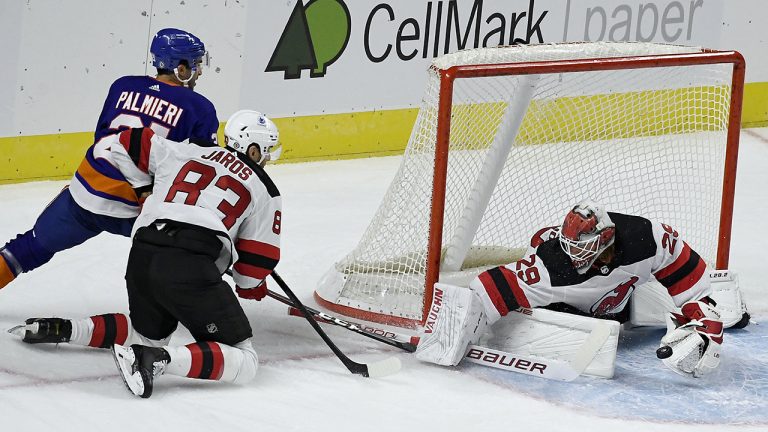 New Jersey Devils goalie Mackenzie Blackwood, right, makes a save on a shot attempt by New York Islanders' Kyle Palmieri, as New Jersey Devils' Christian Jaros defends. (Jessica Hill/AP)