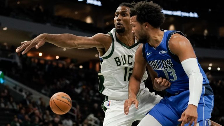 Dallas Mavericks' Jalen Brunson passes the ball around Milwaukee Bucks' Javin DeLaurier during the first half of an NBA preseason basketball game Friday, Oct. 15, 2021, in Milwaukee. (Morry Gash/AP) 
