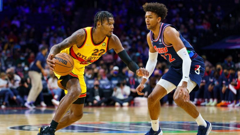 Atlanta Hawks' Cam Reddish, left, makes his move against Philadelphia 76ers' Matisse Thybulle, right, during the first half of an NBA basketball game Thursday, Dec. 23, 2021, in Philadelphia. (Chris Szagola/AP) 
