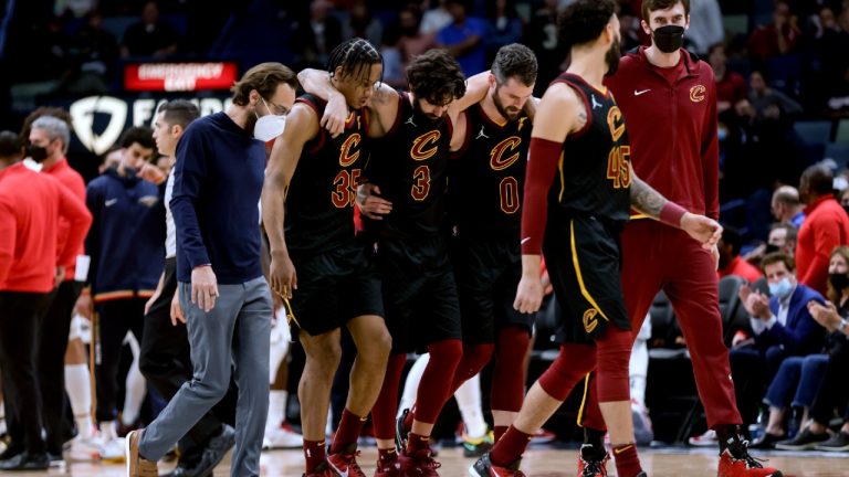 Cleveland Cavaliers guard Ricky Rubio (3) is assisted off the court by teammates during the fourth quarter of the team's NBA basketball game against the New Orleans Pelicans in New Orleans, Tuesday, Dec. 28, 2021. (Derick Hingle/AP) 
