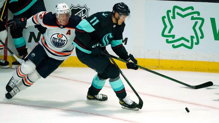 Seattle Kraken's Alexander True (11) skates past Edmonton Oilers' Tyson Barrie in the first period of a preseason NHL hockey game Friday, Oct. 1, 2021, in Everett, Wash. (Elaine Thompson/AP) 