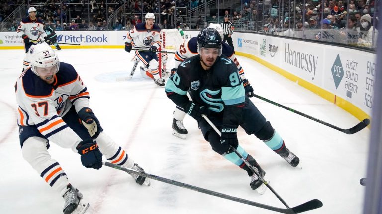 Edmonton Oilers' Warren Foegele (37) and Seattle Kraken's Marcus Johansson chase a loose puck in the second period of an NHL hockey game Saturday, Dec. 18, 2021, in Seattle (Elaine Thompson/AP).