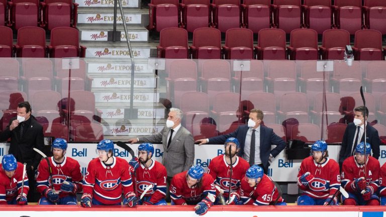 Montreal Canadiens players and coaching staff look on from the bench against a backdrop of empty seats during second period NHL hockey action against the Philadelphia Flyers in Montreal, Thursday, December 16, 2021. (Graham Hughes/CP)