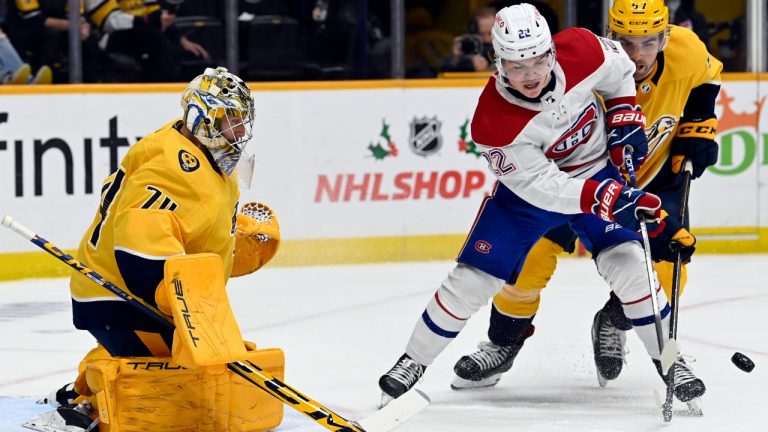 Montreal Canadiens right wing Cole Caufield (22) and Nashville Predators defenceman Dante Fabbro (57) vie for the puck in front of Predators goaltender Juuse Saros (74) during the first period of an NHL hockey game Saturday, Dec. 4, 2021, in Nashville, Tenn. (Mark Zaleski/AP)