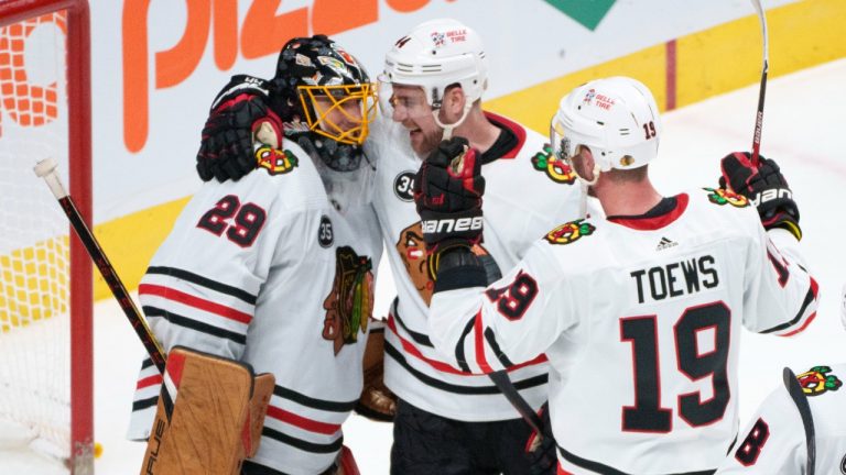 Chicago Blackhawks' Calvin de Haan, centre and Jonathan Toews congratulate goaltender Marc-Andre Fleury for his 500th career NHL win after shutting out the Montreal Canadiens 2-0 in NHL hockey action in Montreal on Thursday, December 9, 2021. (Paul Chiasson/CP)