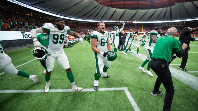 Saskatchewan Roughriders' Jonathan Woodard (99) and Evan Johnson (64) celebrate after Saskatchewan defeated the B.C. Lions during a CFL football game in Vancouver, on Friday, September 24, 2021. (Darryl Dyck/CP)