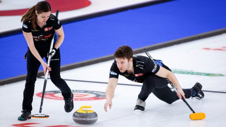 Team Walker/Muyres third Kirk Muyres, right, makes a shot as skip Laura Walker sweeps while they play Team Einarson/Gushue at the Canadian Mixed Doubles Curling Championship in Calgary, Alta., Wednesday, March 24, 2021. (Jeff McIntosh/CP)