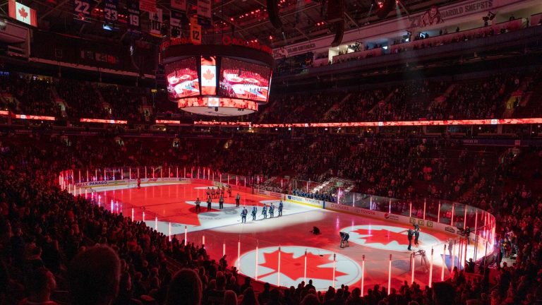 Hockey fans sing along to the Canadian national anthem prior to the NHL pre-season game between the Vancouver Canucks and the Edmonton Oilers in Vancouver, Saturday, October 9, 2021. (Jonathan Hayward/THE CANADIAN PRESS)
