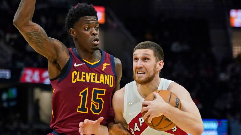 Toronto Raptors' Svi Mykhailiuk (14) drives against Cleveland Cavaliers' Tre Scott (15) in the second half of an NBA basketball game, Sunday, Dec. 26, 2021, in Cleveland. (Tony Dejak/AP Photo) 
