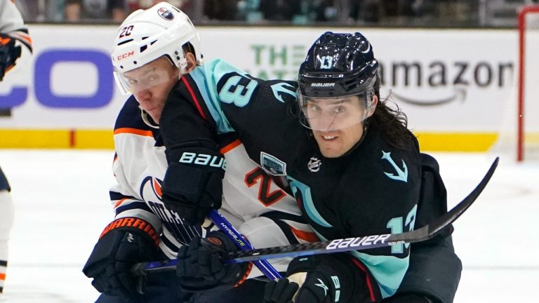 Seattle Kraken's Brandon Tanev right, and Edmonton Oilers' Slater Koekkoek become entangled as they chase the puck in the first period of an NHL hockey game Saturday, Dec. 18, 2021, in Seattle. (Elaine Thompson/AP)