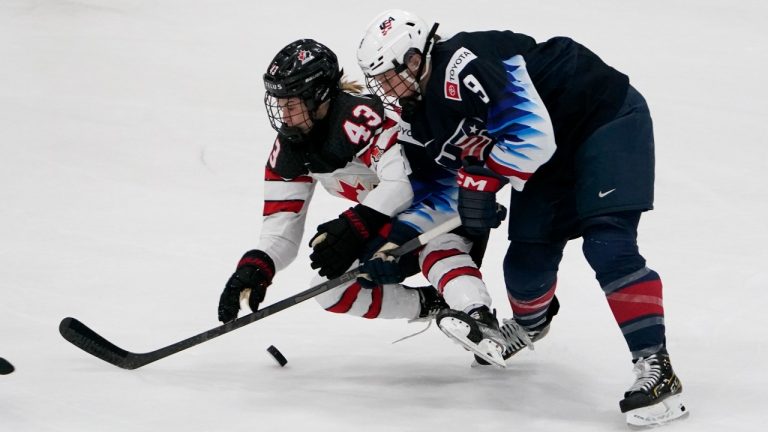 Canada's Kristin O'Neill (43) and United States' Megan Bozek (9) battle for a loose puck during the second period of a women's exhibition hockey game ahead of the Beijing Olympics Wednesday, Dec. 15, 2021, in Maryland Heights, Mo. (Jeff Roberson/AP Photo) 
