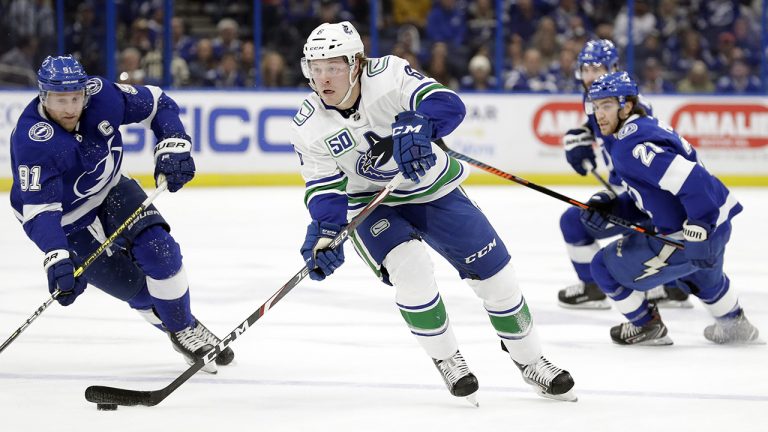 Vancouver Canucks right wing Brock Boeser (6) carries the puck past Tampa Bay Lightning centre Steven Stamkos (91) and centre Brayden Point (21). (Chris O'Meara/AP)