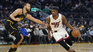 Miami Heat forward Jimmy Butler (22) drives to the basket against Golden State Warriors guard Stephen Curry during the first half of an NBA basketball game. (Jeff Chiu/AP)