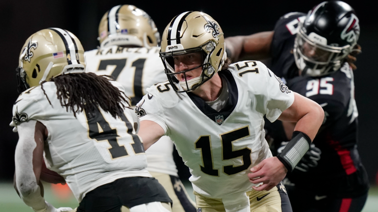 New Orleans Saints quarterback Trevor Siemian (15) hands the ball off to New Orleans Saints running back Alvin Kamara (41) during the second half against the Atlanta Falcons, Sunday, Jan. 9, 2022, in Atlanta. (AP) 