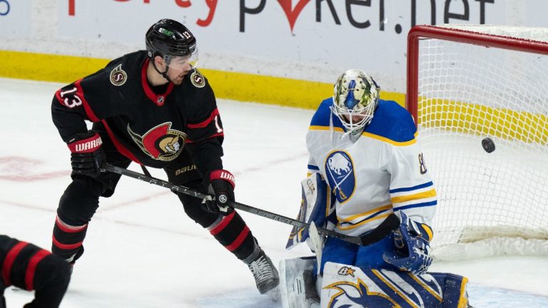 Ottawa Senators left wing Zach Sanford lifts the puck past Buffalo Sabres goaltender Aaron Dell and over the net during second period NHL action, Tuesday, Jan. 25, 2022 in Ottawa. (Adrian Wyld/CP) 
