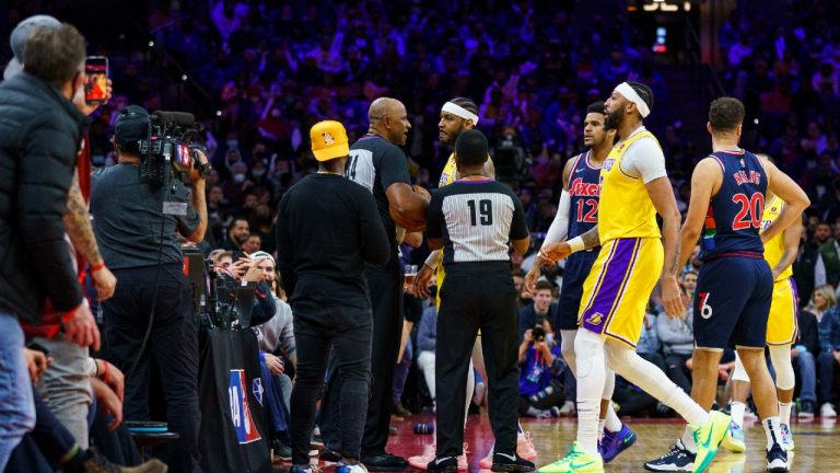 Los Angeles Lakers' Carmelo Anthony, top center, is held back by officials after having a word with a fan in the stands during the second half of an NBA basketball game against the Philadelphia 76ers, Thursday, Jan. 27, 2022, in Philadelphia. (Chris Szagola/AP) 
