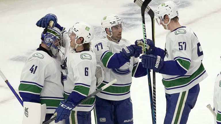 From left to right, Vancouver Canucks goaltender Jaroslav Halak, Brock Boeser, Brad Hunt and Tyler Myers celebrate their win over the Chicago Blackhawks. (AP)