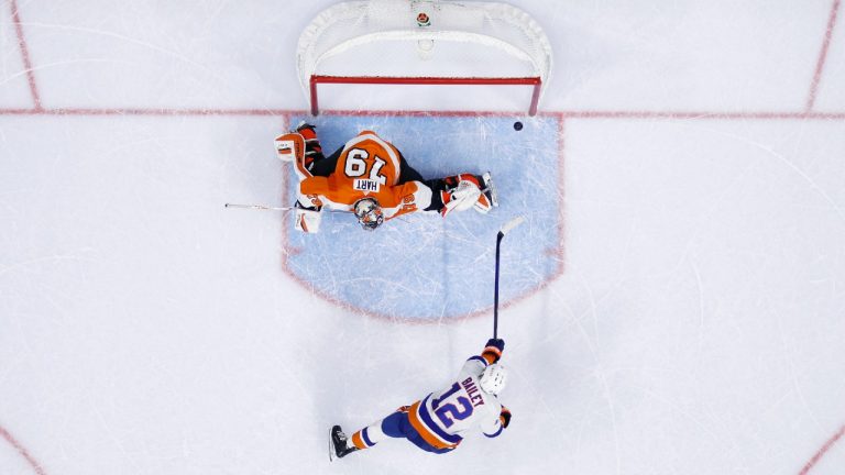 Philadelphia Flyers' Carter Hart, top, blocks a shot by New York Islanders' Josh Bailey during a shootout in an NHL hockey game, Tuesday, Jan. 18, 2022, in Philadelphia. (Matt Slocum/AP) 