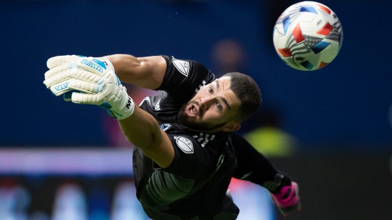 Vancouver Whitecaps goalkeeper Maxime Crepeau dives to get a piece of the ball before it deflects off the post and stays out of the goal during the first half of an MLS soccer game against Real Salt Lake in Vancouver, on Sunday, August 29, 2021. (Darryl Dyck/The Canadian Press)