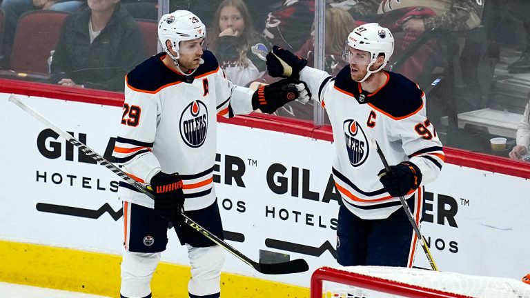 Edmonton Oilers centre Leon Draisaitl (29) celebrates his goal against the Arizona Coyotes with Oilers centre Connor McDavid (97) during the second period of an NHL hockey game. (Ross D. Franklin/AP)