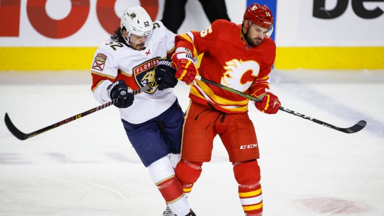 Florida Panthers' MacKenzie Weegar, left, is checked by Calgary Flames' Brad Richardson during first period NHL hockey action in Calgary, Tuesday, Jan. 18, 2022.(Jeff McIntosh/CP)
