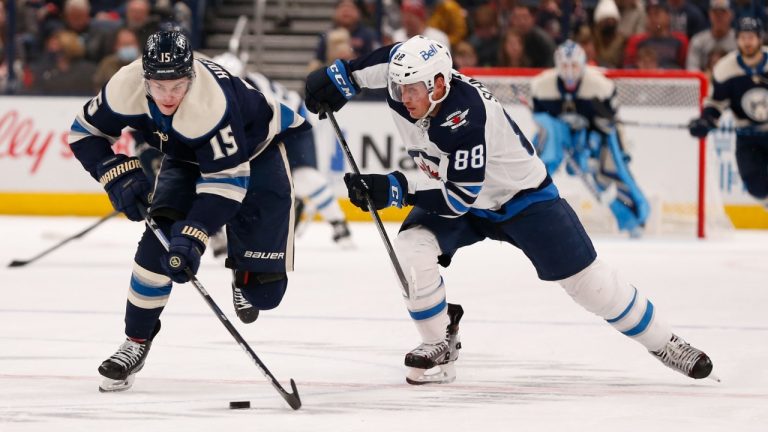 Columbus Blue Jackets' Gregory Hofmann, left, and Winnipeg Jets' Nate Schmidt chase a a loose puck during the second period of an NHL hockey game Wednesday, Nov. 24, 2021, in Columbus, Ohio. (Jay LaPrete/AP Photo) 
