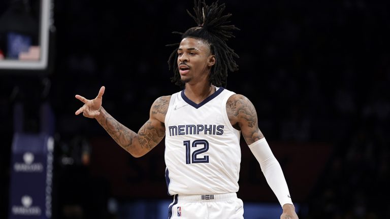 Memphis Grizzlies guard Ja Morant (12) reacts after making a three-point basket during the first half of an NBA basketball game. (Adam Hunger/AP)