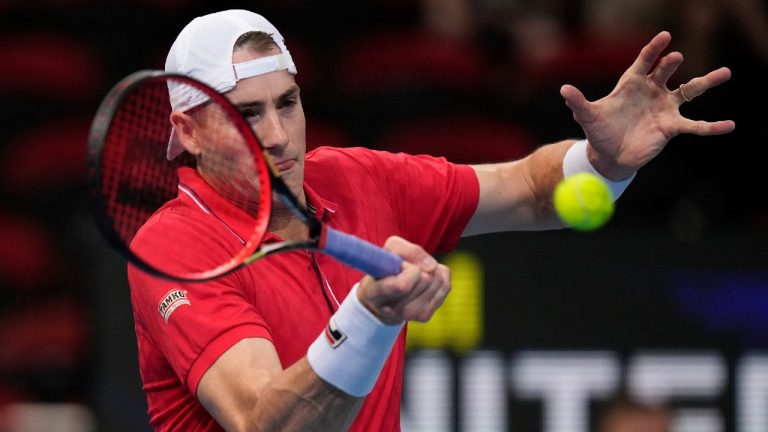 United States' John Isner hits a forehand to Canada's Brayden Schnur match at the ATP Cup tennis tournament in Sydney, Sunday, Jan. 2, 2022 (Rick Rycroft/AP).