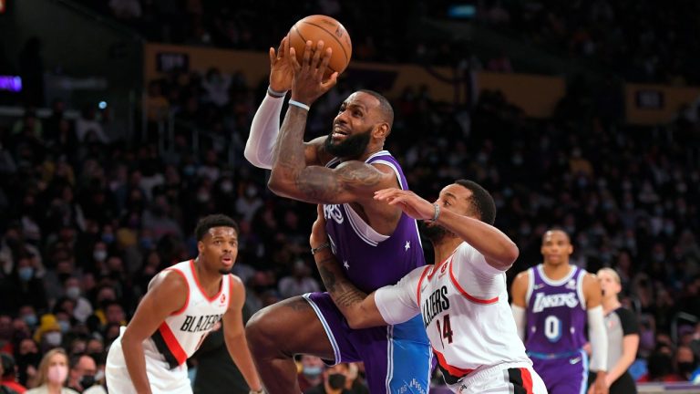 Los Angeles Lakers forward LeBron James (6) gets past Portland Trail Blazers forward Norman Powell (24) during the first half of an NBA basketball game Friday Dec. 31, 2021, in Los Angeles. (John McCoy/AP Photo) 
