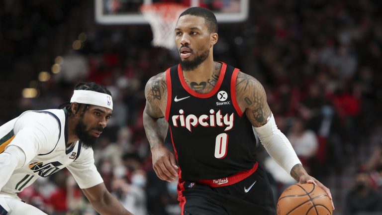 Portland Trail Blazers guard Damian Lillard dribbles past Utah Jazz guard Mike Conley. (Amanda Loman/AP)