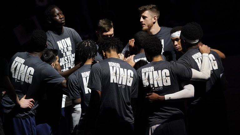 Wearing shirts to honour Dr. Martin Luther King, Jr., Denver Nuggets huddle afte being introduced before the first half of an NBA basketball game. (David Zalubowski/AP)